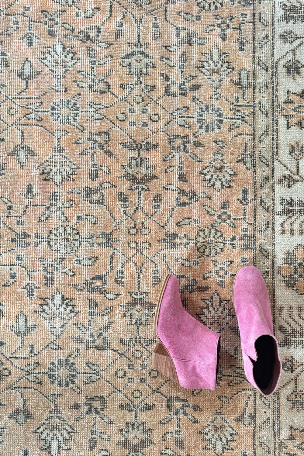 'Hallieford' Vintage Turkish Rug - 5'6" x 9'2.5" - Canary Lane
Close up of a vintage handwoven Turkish area rug featuring intricate floral motifs and wide, neutral borders. The design incorporates peach, brown, and cream, blending warm tones for a harmonious look. Its rich texture and timeless aesthetic add depth and elegance, making it a perfect focal point for any room.