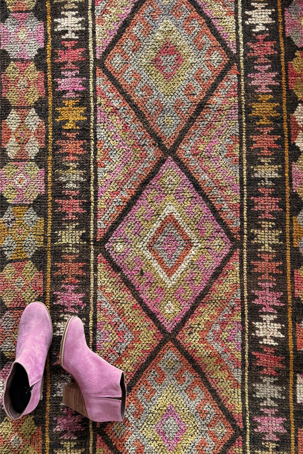'Milford' Vintage Turkish Runner - 2'11.5" x 12'1" - Canary Lane
Close up of a vintage handwoven Turkish runner featuring an intricate diamond pattern and rich textures. The design showcases traditional craftsmanship and detailed motifs. The color palette includes brown, red, orange, pink, yellow, and gray, creating a harmonious blend of warm and cool tones. 