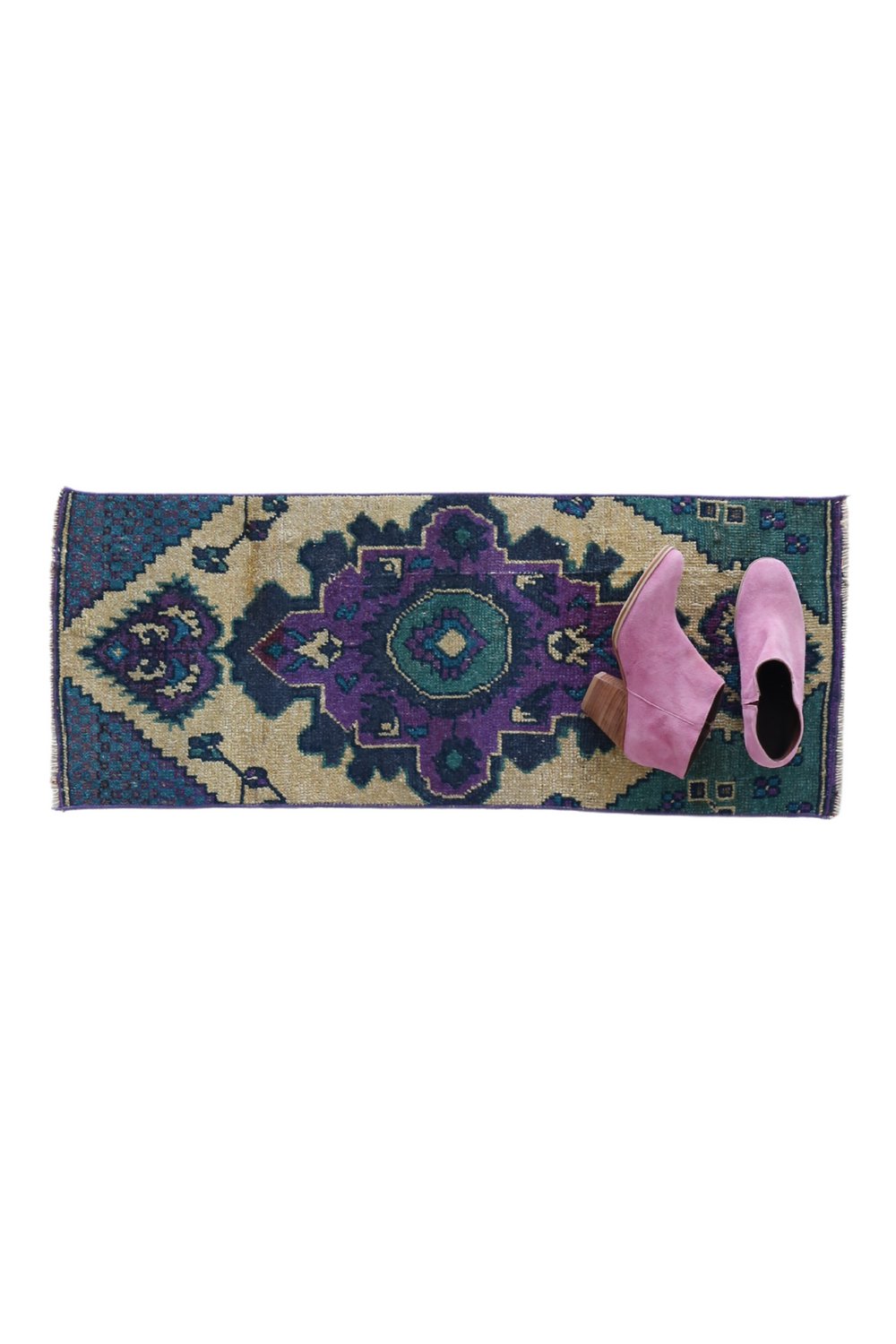 No. 1656 Mini Turkish Vintage Rug - 1'3.5" x 3'2" - Canary Lane
A hand woven rug with a bold geometric design, featuring a central medallion in purple and green tones, surrounded by  intricate teal and beige patterns. 