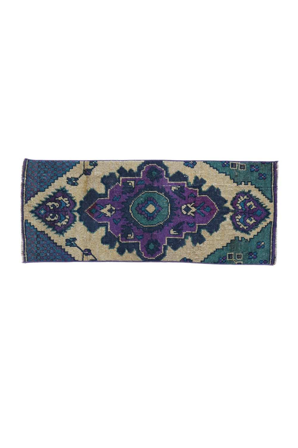 No. 1656 Mini Turkish Vintage Rug - 1'3.5" x 3'2" - Canary Lane
A hand woven rug with a bold geometric design, featuring a central medallion in purple and green tones, surrounded by  intricate teal and beige patterns. 