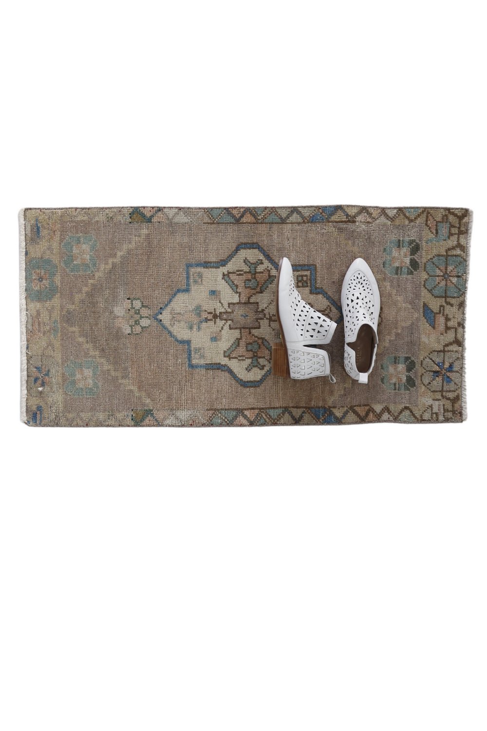 No. 1720 Mini Turkish Vintage Rug - 1'8" x 3'4" - Canary Lane
Muted rectangular rug featuring a central medallion in cream and light blue, accented with geometric floral motifs. The design includes subtle earthy tones, with hints of beige, green, and blue, framed by a decorative border with triangular and floral patterns.